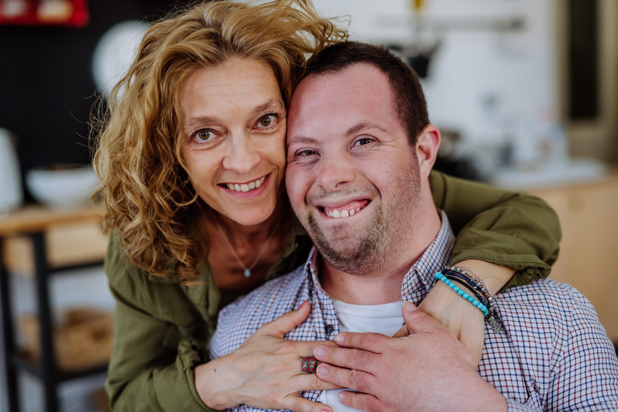 man with autism being hugged by supportive woman