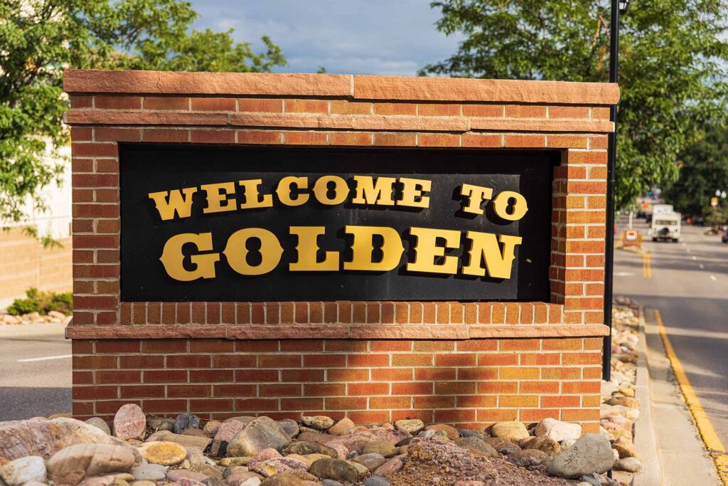Brick framed sign reading "Welcome to Golden"